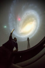A graduate student makes a presentation in the Museum of Natural History's planetarium