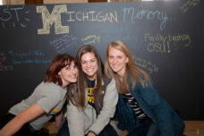 Graduating students post a favorite memory on a chalkboard during a Senior Send-Off event.