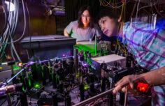 A professor and assistant preparing a mesoscopic semiconductor laser table.