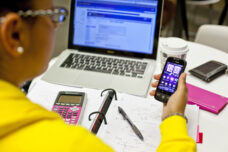A student checks the time while doing her homework at Bert's Cafe in the Shapiro Undergraduate Library.
