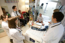 U-M medical students and residents talk to a patient and her mother during morning rounds at C.S. Mott Children's Hospital.