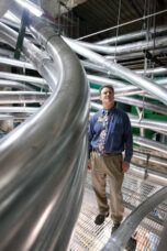 A staff member inspects the pneumatic tubes that carry patient-related messages in mechanical space at the U-M Health System.