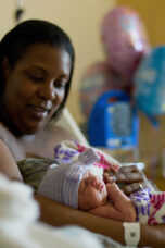 A proud mother holds her hours-old newborn girl at C.S. Mott Children's Hospital.