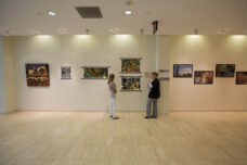 Visitors look at staff artwork in the Building 18 Rotunda Gallery at the North Campus Research Center.
