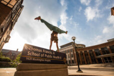 A student shows off her parkour skills outside of the School of Public Health.